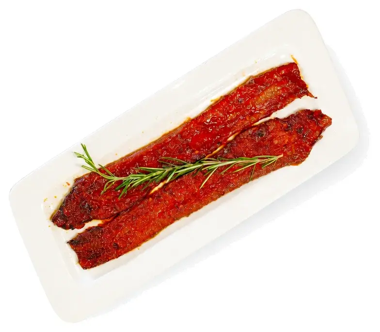 Thick-cut bacon with rosemary on a white plate